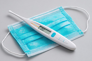 Thermometer on surgical mask for health safety, a Health & Medical Photo by AlyaAnd