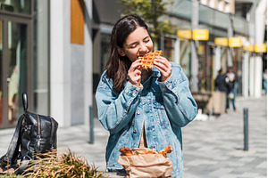 Woman in her 20s takes a bite of a, a Person Photo by AD Stock Images