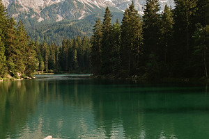 Serene Alpine Lake with Rowboat, a Nature Photo by Virgo Studio