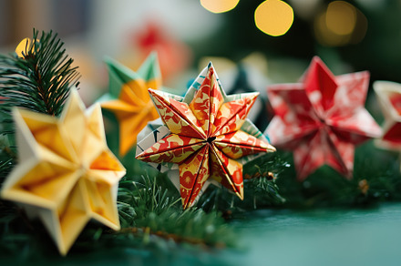 Colorful origami stars arranged on a green surface, surrounded by pine branches, an Arts & Entertainment Photo by Textures & Backgrounds