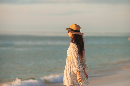 Young beautiful woman at straw hat on the beach at sunset, a Person Photo by travnikovstudio
