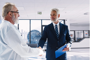 Doctor shaking hand with hospital, a Health & Medical Photo by HalfPoint