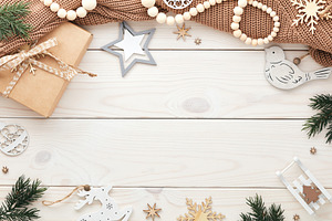 Cozy hygge Christmas composition. White wooden desk table with brown woolen swe