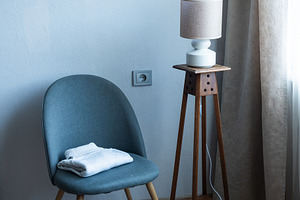 Cozy armchair with folded blanket in modern minimalist living ro, an Industrial Photo by MDBildes