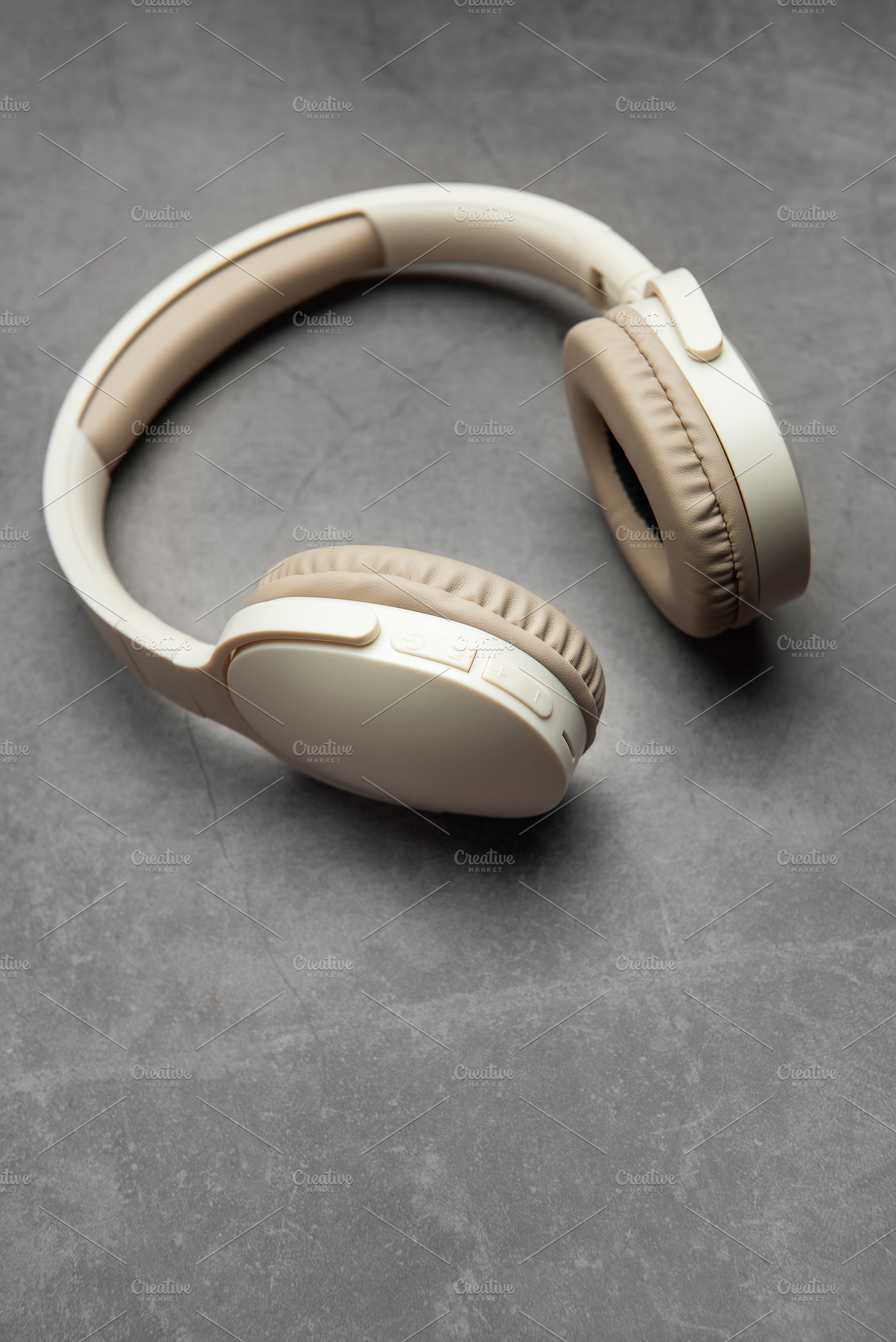 Wireless headphones resting on gray surface, a Technology Photo by Olena Rudo