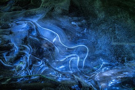 Network of cracks in thick solid frozen layer of ice with shining light, an Abstract Photo by sergey.krotov