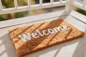 Cozy welcome mat placed at the entrance of a sunny balcony in the afternoon, a Background Photo by AlyaAnd