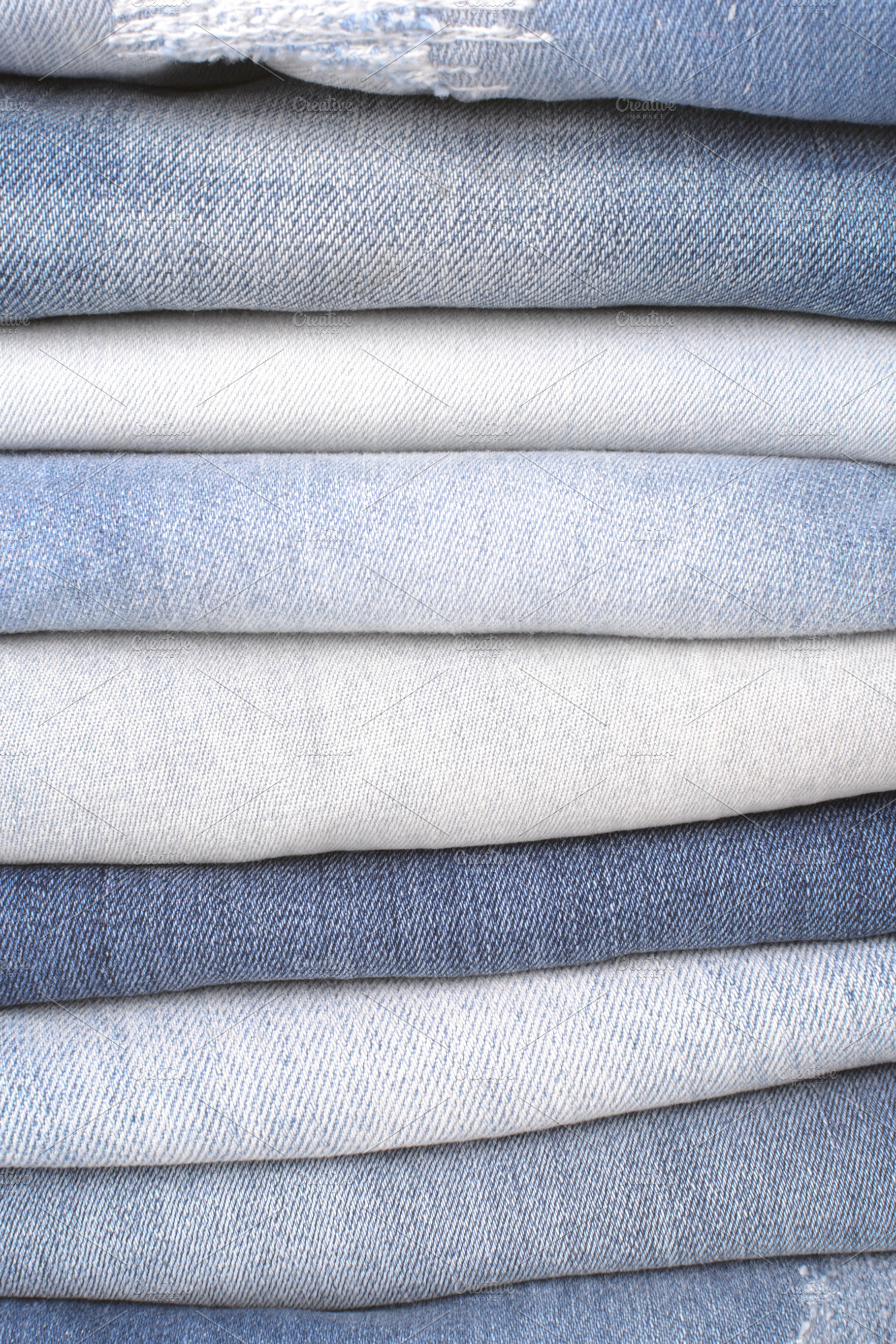 Stack of folded jeans containing jeans, denim, and close up