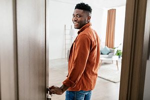 Joyful African American Male Entering His New Apartment Opening Door, a Photo by Prostock-Studio