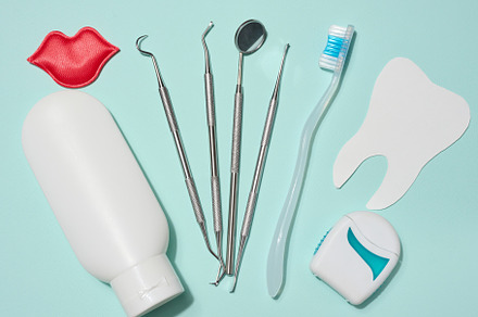 Red decorative lips, white tube of toothpaste, dental floss in w