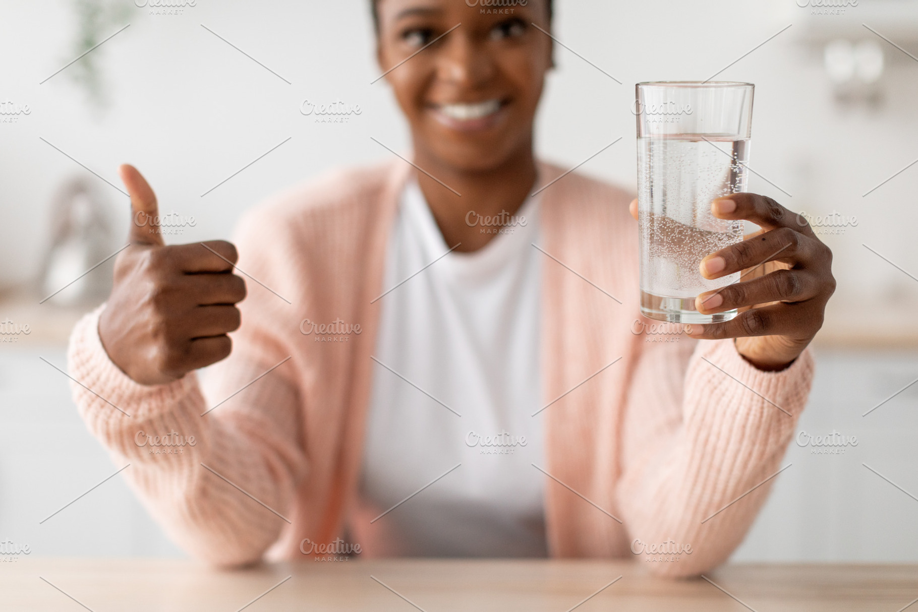 Happy young african american lady hold glass of clean water and show thumb up i, a Person Photo by Prostock-Studio
