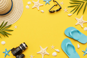 Summer accessories framing vibrant yellow background for travel, a Holiday Photo by Olena Rudo