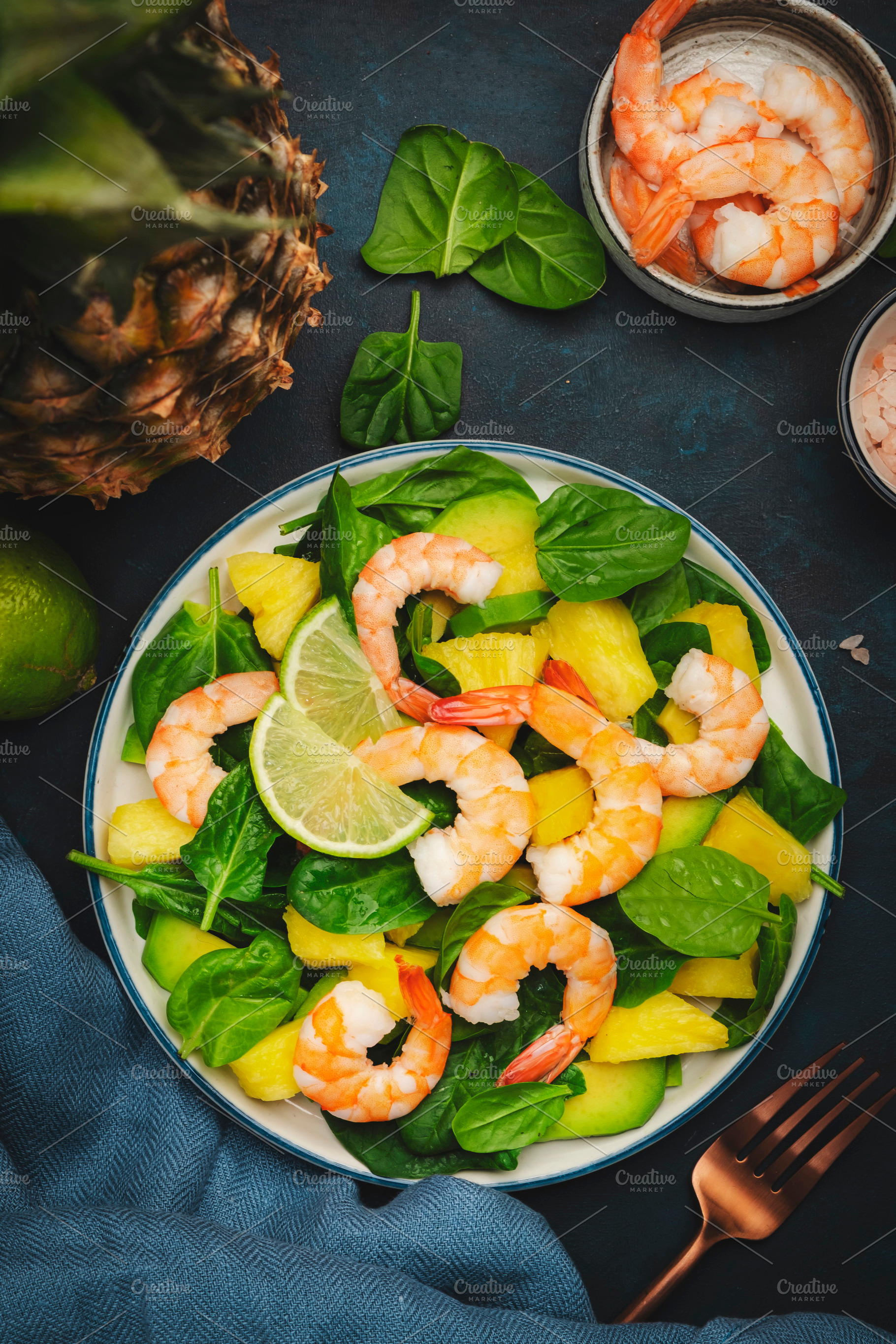 Pineapple salad with shrimps, spinach, avocado and lime on blue, a Food & Drink Photo by 5PH