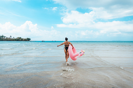 Summer travel, woman holding an inner tube, walking in the middl, a Nature Photo by Art Rachen