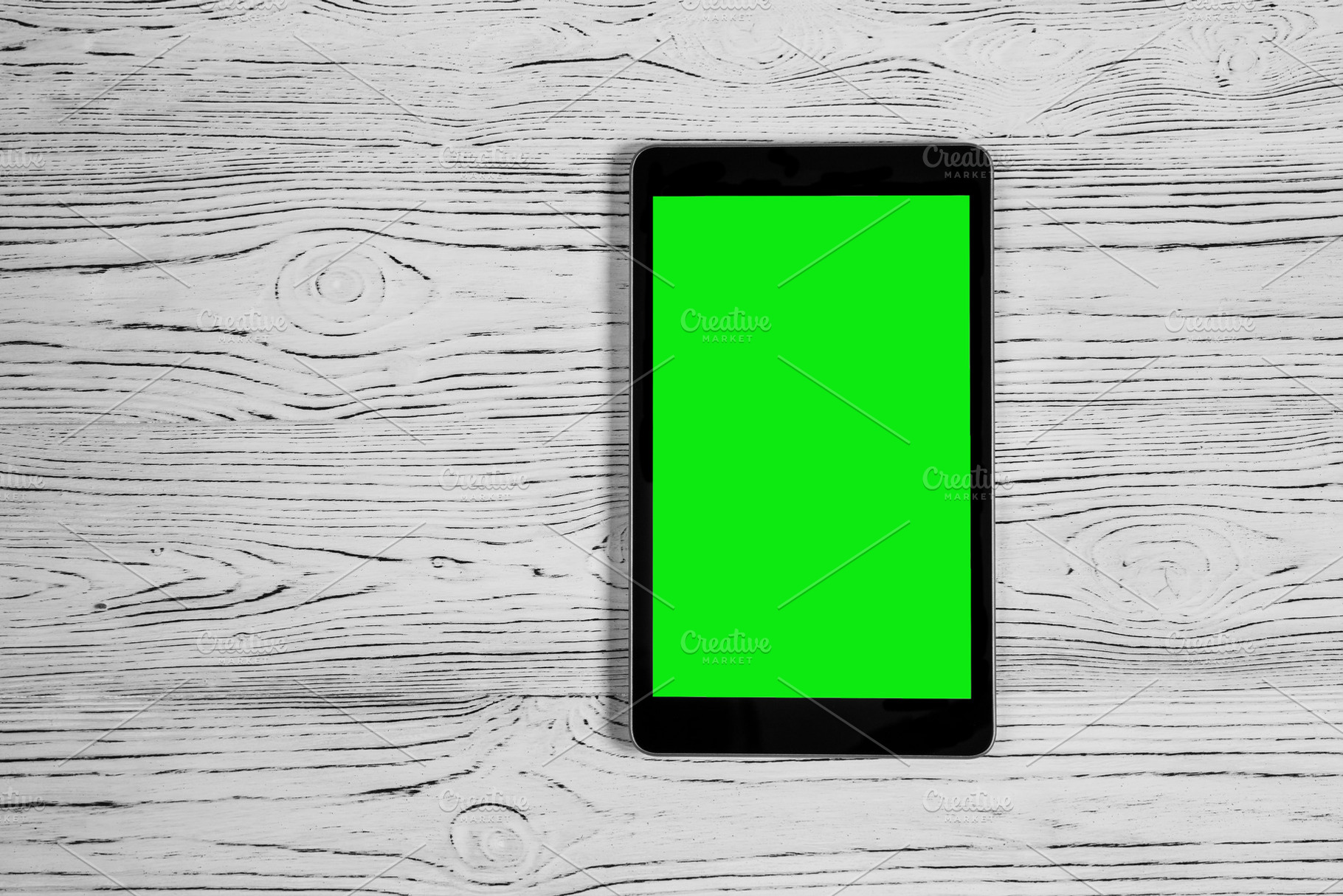 Black tablet with green screen on a wooden table mock up. Copy s, an Abstract Photo by Eugene_Photo