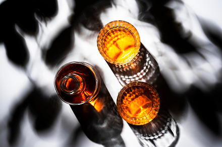 Whiskey in glasses and bottle, white background with hard light,, a Food & Drink Photo by 5PH