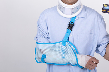 Asian man with broken arm and neck showing a credit card isolate