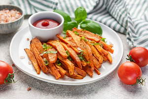 Sweet potato fries with ketchup and basil on plate, a Food & Drink Photo by Olena Rudo
