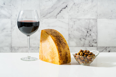 a piece of parmesan or pecorino cheese on a white table and red, a Food & Drink Photo by IriGri