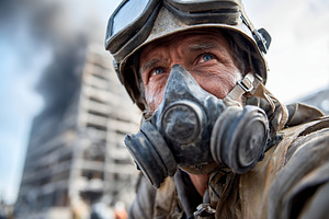 Soldier in protective gear during urban conflict with smoke rising in backgroun, a Photo by AlyaAnd