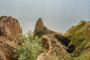 A panoramic view of steep clay cliffs covered with grass and shr, a Nature Photo by ndanko