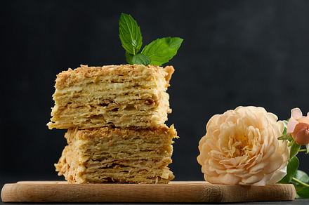 A stack of baked Napoleon pie slices with cream. Puff pastry, delicious dessert, a Food & Drink Photo by ndanko