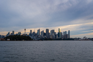 Sydney skyline at sunset with golden reflections on the water, an Architecture Photo by GoodGoods