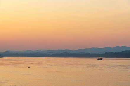serene sunset over river, with soft orange and pink hues reflecting on water. S, a Photo by a454