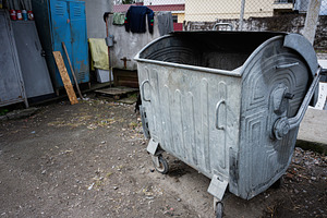 Large old metal trash container in an outdoor urban setting, a Photo by AS photostudio