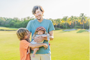 Father, son, and newborn on a meadow, a Holiday Photo by Elizaveta Galitskaya