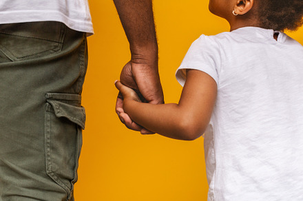 Little african girl holding her dadd, a Background Photo by Prostock-Studio