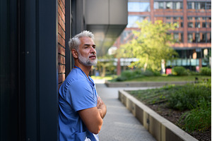 Healthcare worker outside hospital, a Health & Medical Photo by HalfPoint