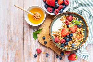 Healthy breakfast granola with fresh berries and honey, a Food & Drink Photo by Olena Rudo