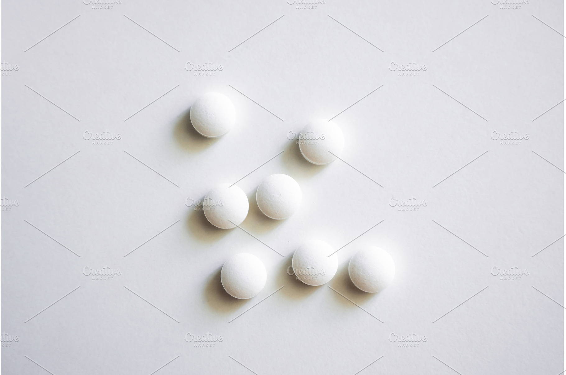 Set of seven round white tablets, a Health & Medical Photo by volodymyrshtun13795