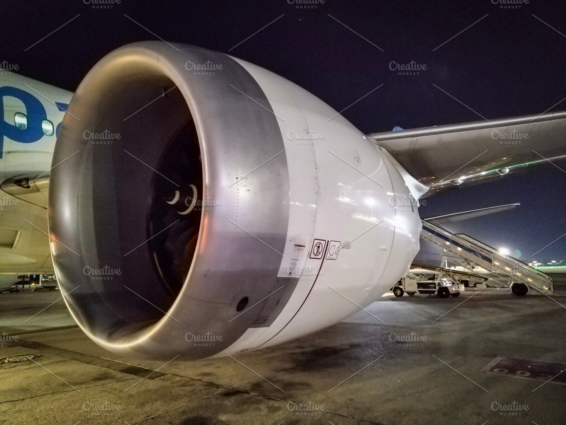 Airplane turbine at night seen from runway close-up, a Transportation Photo by DanFLCreativo