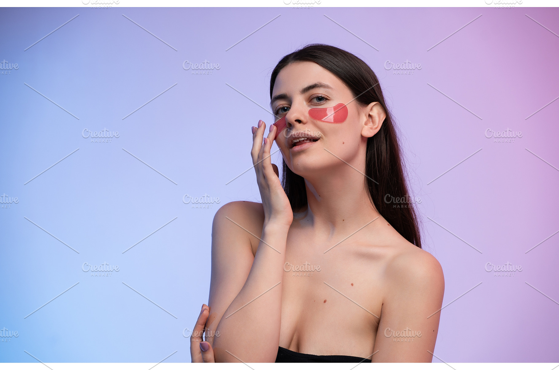 Young woman applying red eye patches, a Health & Medical Photo by volodymyrshtun13795