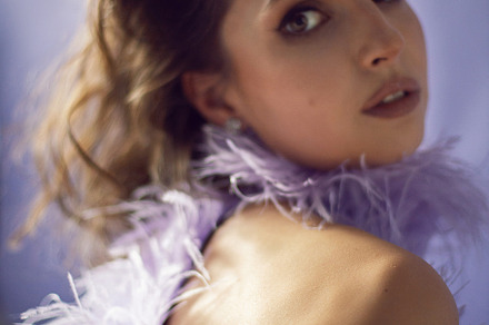portrait woman in an evening purple dress with feathers stands in the backgroun, a Person Photo by SaulichPhoto