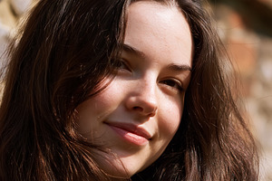 Young woman smiling with brown long hair feeling happiness in na, a Person Photo by Studio ANNA