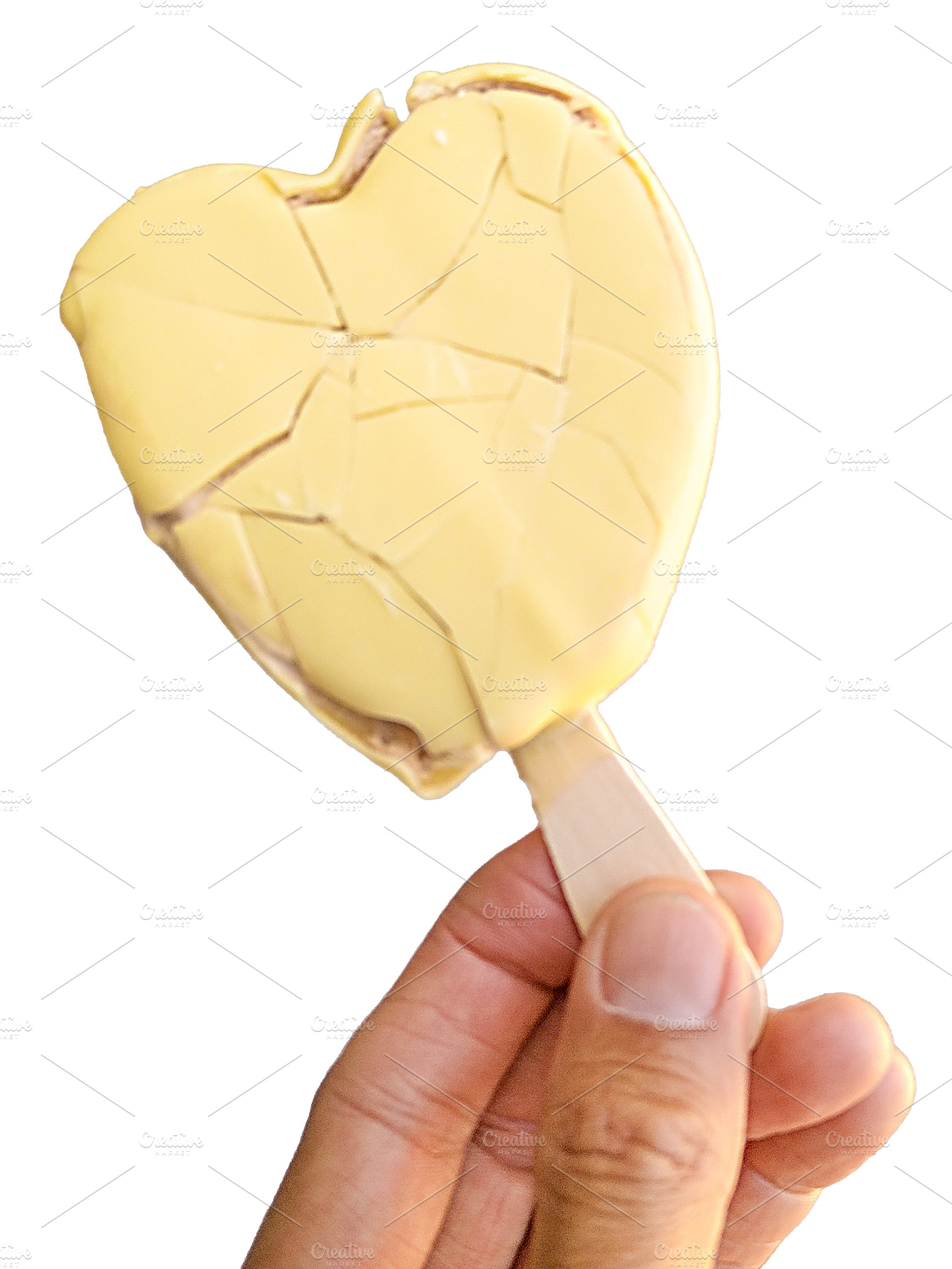 Hand holding heart-shaped lollipop ice cream on street, a Food & Drink Photo by DanFLCreativo