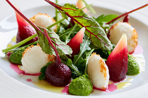 Beetroot and goat cheese salad on a white plate, featuring fresh arugula, vibra, a Photo by Studio ANNA