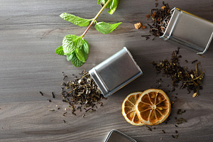 Dried black tea leaves spilling out of a metal containers, a Food & Drink Photo by Davizro's Market