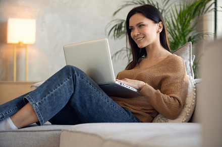 Smiling woman using laptop, a Person Photo by OPOLJA