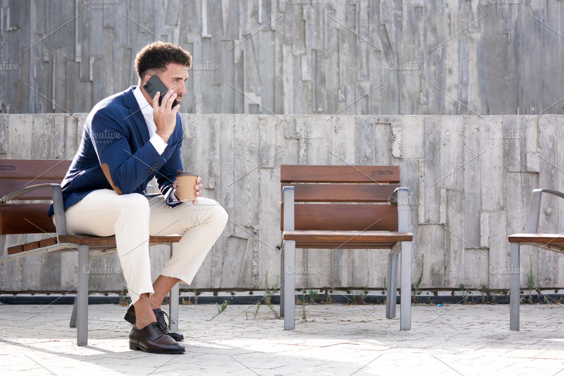 Businessman talking on smartphone outside modern office building, a Photo by etorres69