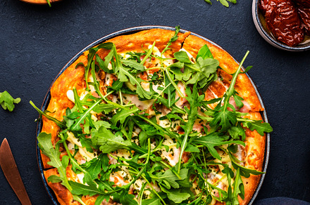 Hot pizza with mozzarella cheese, ham, pesto and fresh arugula,, a Food & Drink Photo by 5PH