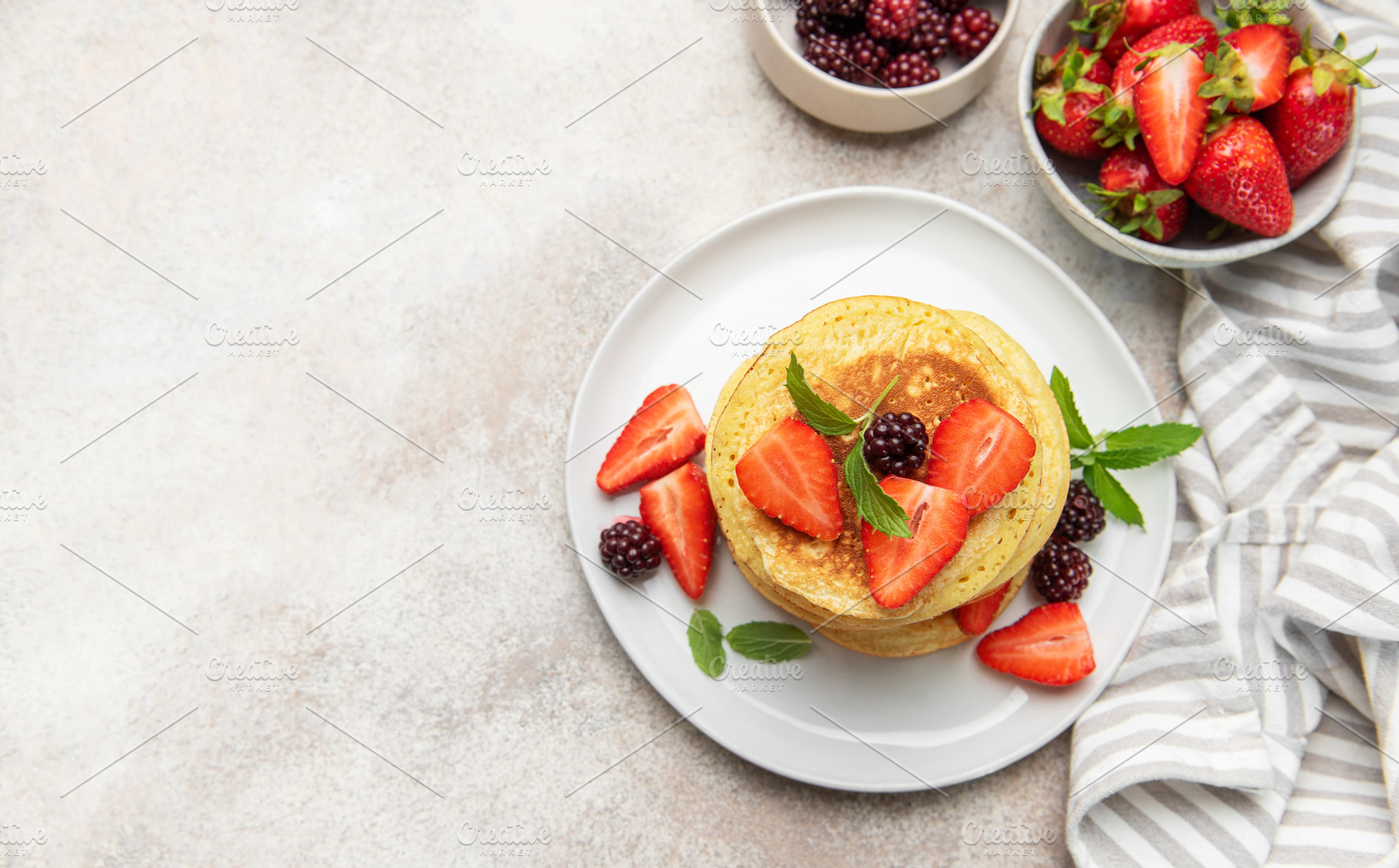 Stacking berry pancakes for a delicious breakfast meal, a Food & Drink Photo by Olena Rudo