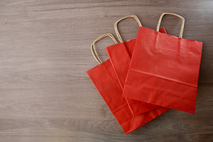 Pack of three red paper shopping bag on wooden table, an Industrial Photo by Davizro's Market