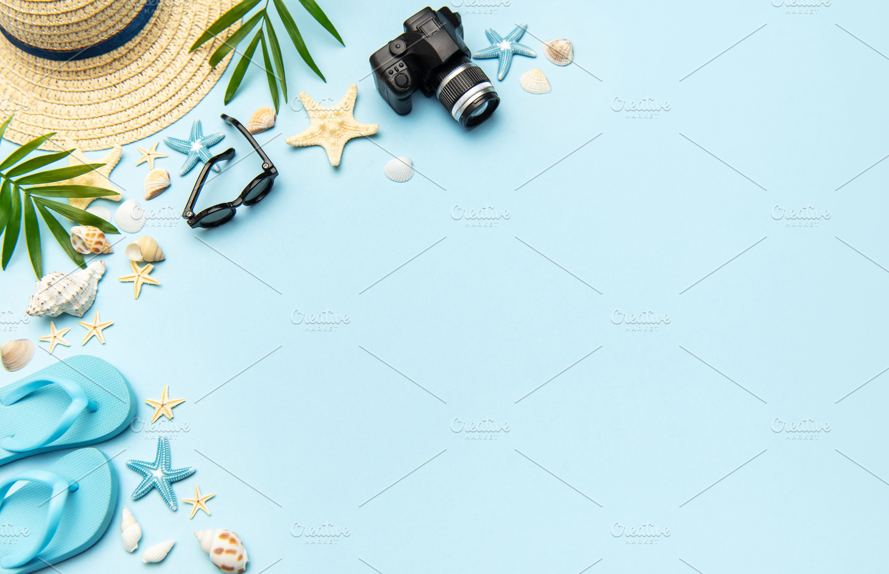 Summer accessories creating frame on light blue background with, a Holiday Photo by Olena Rudo