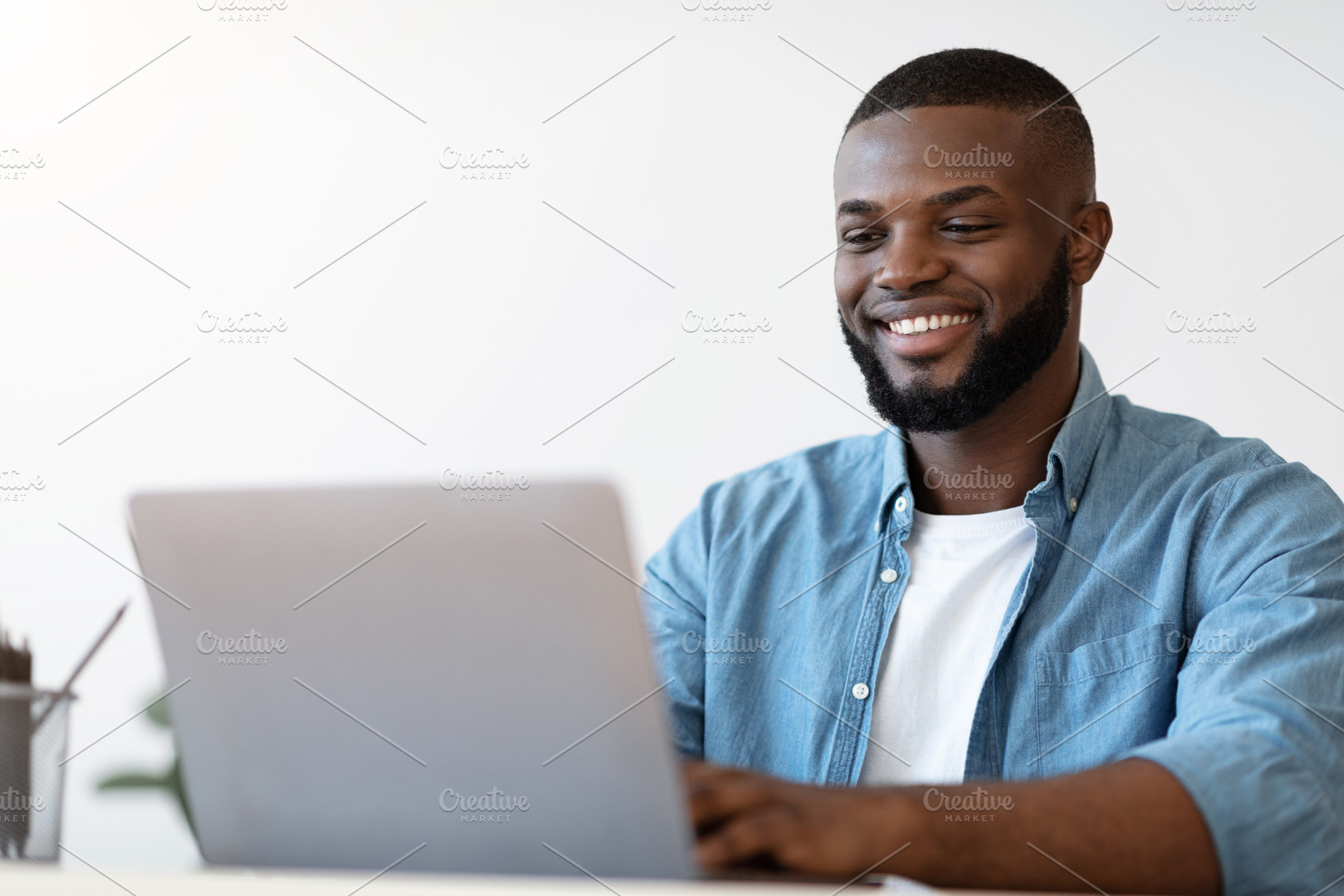 Handsome Black Male Office Employee Working On Laptop Computer, Closeup Shot, a Photo by Prostock-Studio