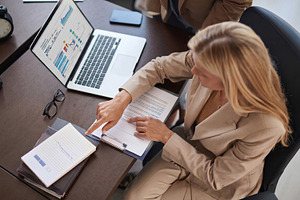 Businesswoman Reviewing Financial Reports at Office Desk, a Business Photo by Davizro's Market