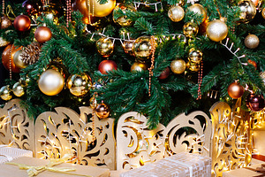 Decorated christmas tree in gold and containing ball, bauble, and bead